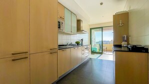 A modern kitchen with a sliding glass door leading to a balcony.