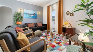 A modern living room with a sofa, a coffee table, and a colorful rug. - (^ ‿ ^) Cozy & Bright, near the Beach, Marina, Historic Center and Supermarket (Lagos)