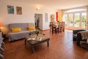Una sala de estar con sofá, mesa de centro y comedor.