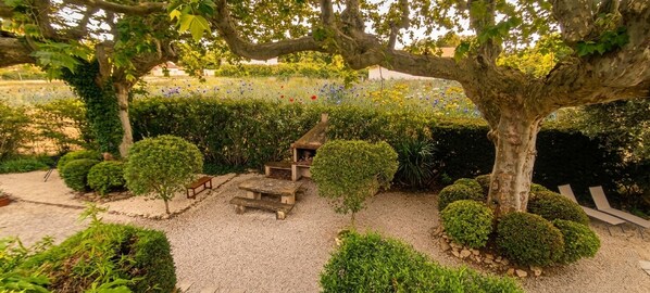 A garden with a gazebo, benches, and trimmed bushes. - Old Mas in Provence with swimming pool (Cabannes)