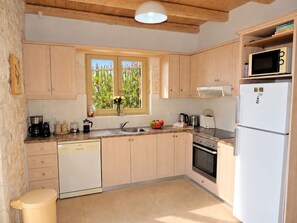 Une cuisine avec des meubles de rangement en bois, un évier, un lave-vaisselle, une cuisinière et un four à micro-ondes.