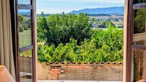 A bedroom with a large window, a bed, and a lamp. - Rural house for groups and hikers, nature and tranquility lovers. (La Torre Vella)
