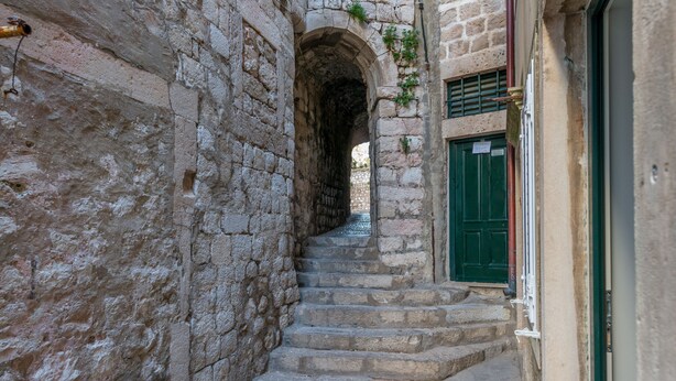 A narrow stone staircase leading up to an arched doorway, flanked by stone walls and a green door. - Petra design apartment Dubrovnik; FREE wireless internet and breakfast! (Dubrovnik)