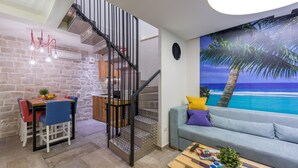 A modern living space with a staircase, dining area, and a large beach mural. - Petra design apartment Dubrovnik; FREE wireless internet and breakfast! (Dubrovnik)