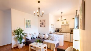 A modern living room with a sofa, a coffee table, and a potted plant. - Cortijo el Chenil rural retreat, La Perrita (Casarabonela)