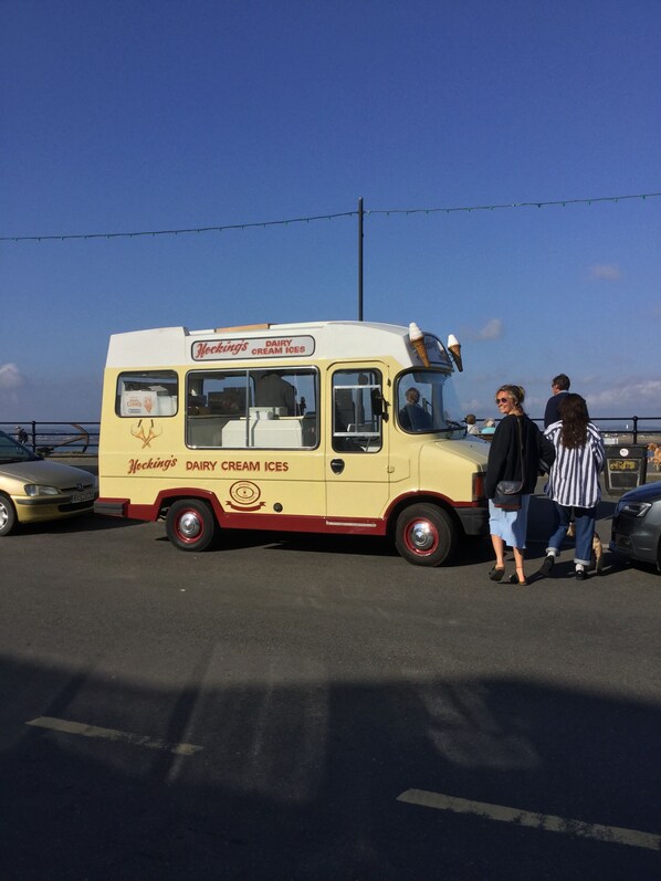 A vintage ice cream truck parked in a lot.