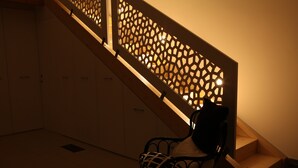 A staircase with a wooden railing and a bench at the bottom.