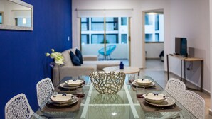 A modern dining area with a glass table, white chairs, and a decorative centerpiece. - Central Huge PH with Private Rooftop and Jacuzzi (Playa del Carmen)