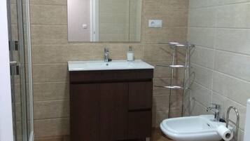 Een haardroger, handdoeken, zeep, toiletpapier