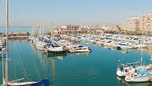 Un port de plaisance où de nombreux bateaux sont amarrés, entouré d’immeubles d’habitation.