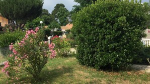 A garden with various plants and a white fence. - Very nice and cozy house 10 minutes from the Bassin   (Arès)