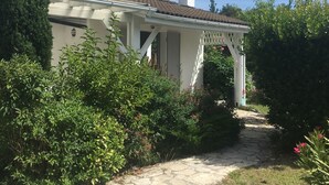 A house with a stone pathway leading to a white porch with a tiled roof. - Very nice and cozy house 10 minutes from the Bassin   (Arès)