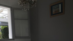A bedroom with a bed, a window, and a chandelier. - Very nice and cozy house 10 minutes from the Bassin   (Arès)