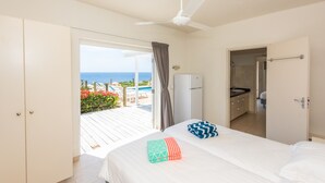 A bedroom with a bed, a bathroom, and a view of the ocean. - Luxury Villa "Lions Cliff" with fantastic views over the Caribbean Sea (St. Willibrordus)