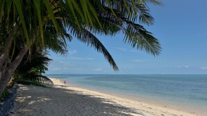 A beach with clear blue water, a sandy shore, and palm trees. - Amazing 3 Bedroom, Thai Style Beachside, Villa (Koh Samui)