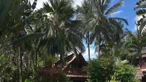 A tropical resort with a large decorative water feature surrounded by lush greenery and palm trees. - Amazing 3 Bedroom, Thai Style Beachside, Villa (Koh Samui)