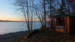 Uma cabana à beira de um lago, com vista para a água e árvores.