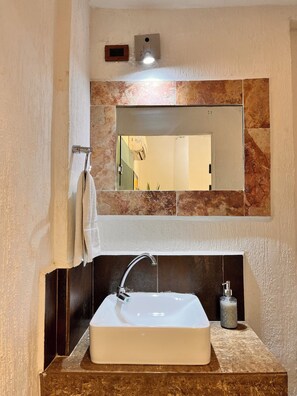 A bathroom with a white sink, a mirror, and a towel rack. - Room in the heart of Cancun (29)