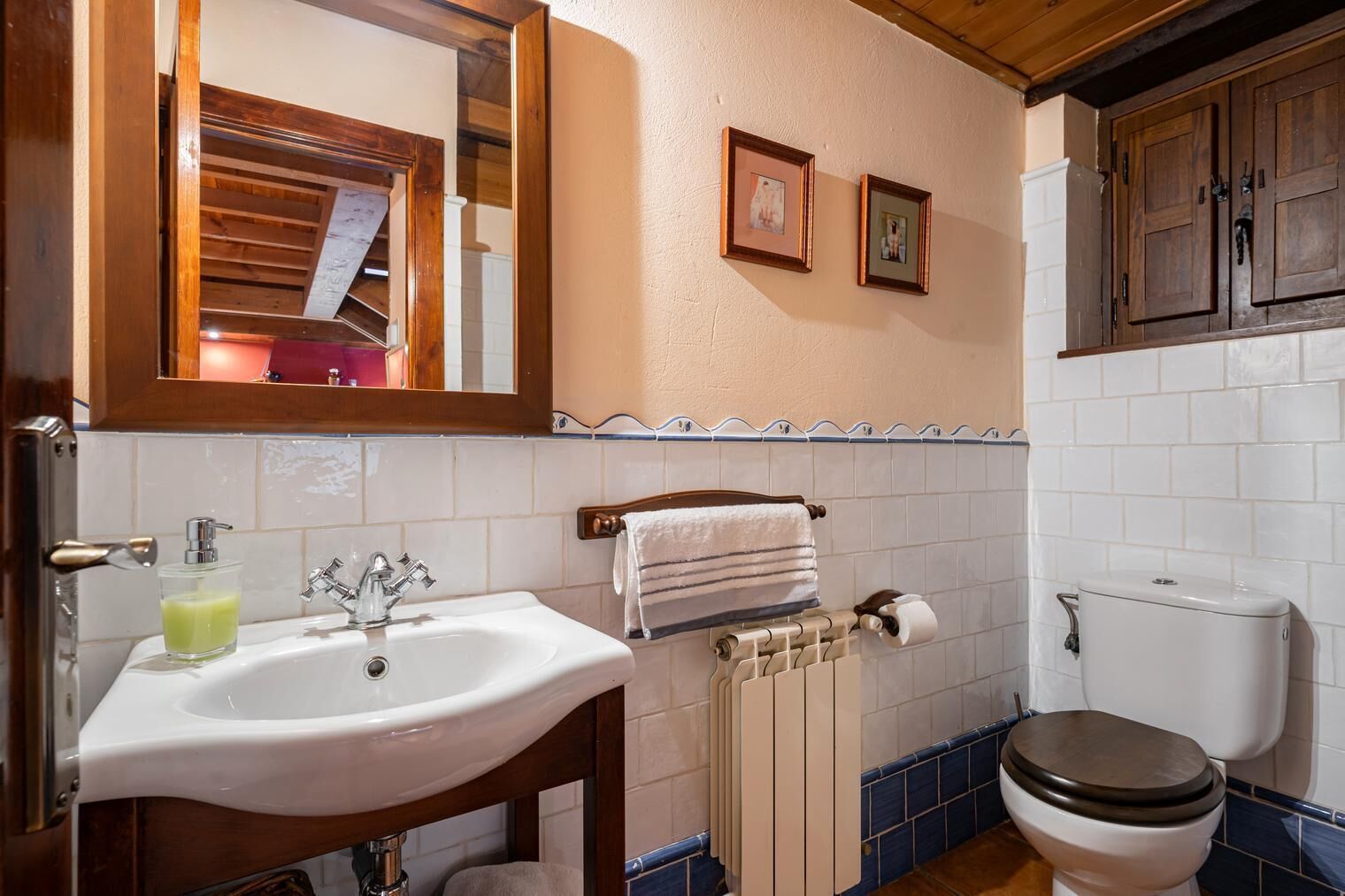Ein Badezimmer mit Waschbecken, Spiegel, Toilette und Handtuchhalter.