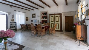 A dining area with wicker chairs, a wooden table, and a chandelier. - Room 5 a/c park view Beach&Sea front Castle parking (Zaton)