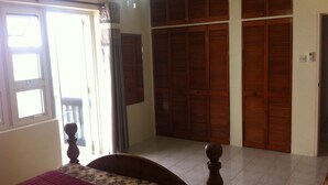 A bedroom with a bed, a wardrobe, and a door leading to a balcony. - Spacious 2 Bed 2 Bath Condo Across From The Beach (CHRIST CHURCH)