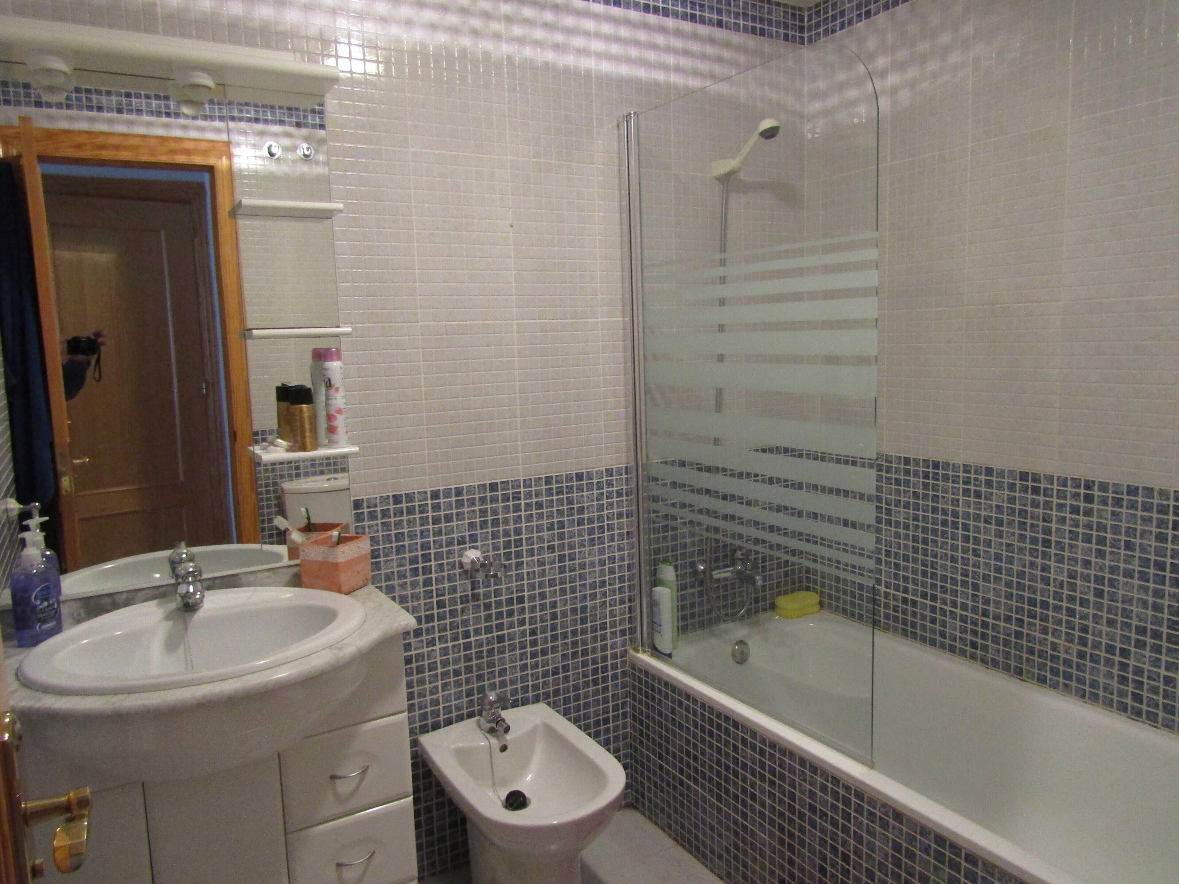 Une salle de bain équipée d’un lavabo, d’un bidet et d’une douche à parois de verre.