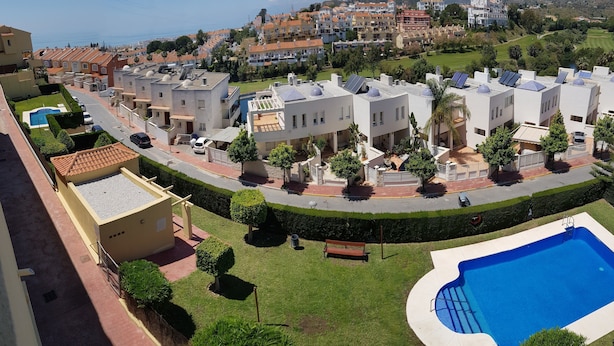 A residential area with modern houses, a swimming pool, and a well-maintained garden. - Apartment rental, golf and beach // golf and beach Apartment (torre de benagalbon)