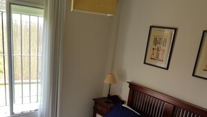 A hotel room with a large bed, a nightstand, a lamp, and two framed pictures on the wall. - Apartment rental, golf and beach // golf and beach Apartment (torre de benagalbon)