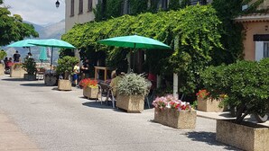 A street with outdoor seating, stone buildings, and greenery. - A 2 bedrooom 2 bath home home with stunning, elevated views, 24km from the sea. (Berre-Les-Alpes)