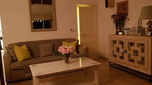 A living room with a sofa, a coffee table, a cabinet, and a window with a mirror. - A 2 bedrooom 2 bath home home with stunning, elevated views, 24km from the sea. (Berre-Les-Alpes)