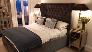 A bedroom with a large bed, a nightstand, a lamp, and a view through a glass door. - A 2 bedrooom 2 bath home home with stunning, elevated views, 24km from the sea. (Berre-Les-Alpes)
