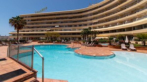 A hotel with a large pool area, multiple balconies, and a clear blue sky. - Santa Maria 99 - One Bed (Costa Adeje)