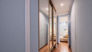 Un couloir étroit avec un plancher en bois et des murs bleu clair.