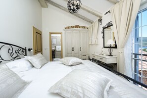 A bedroom with a large bed, a dresser, a mirror, and a window with curtains. - Villa Mek ZadarVillas (Pridraga)