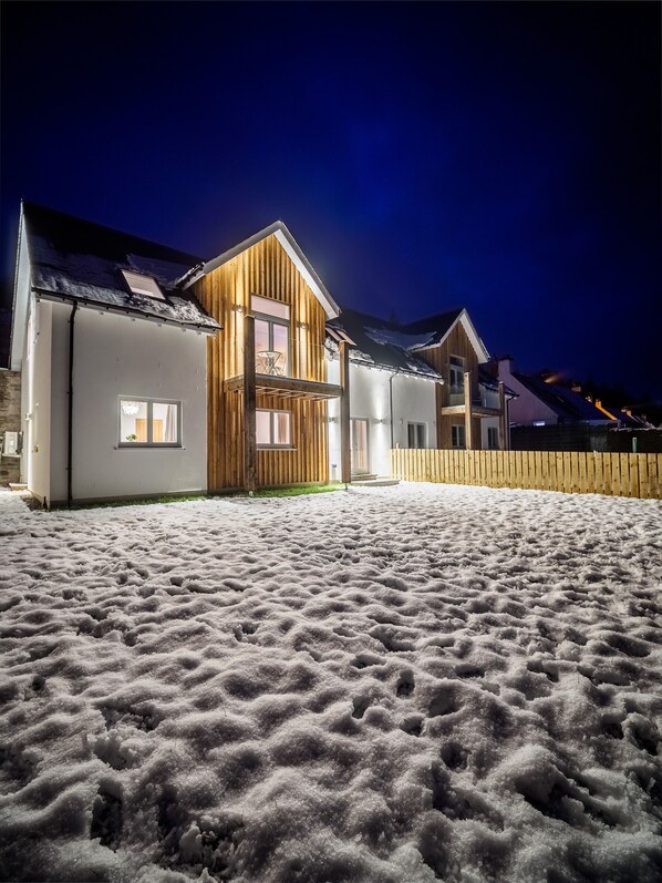 Set against a serene winter backdrop, this charming house features a spacious balcony and inviting exterior.