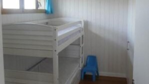 A bunk bed room with a window, a blue chair, and a radiator. - House / Villa - Talais (Talais)