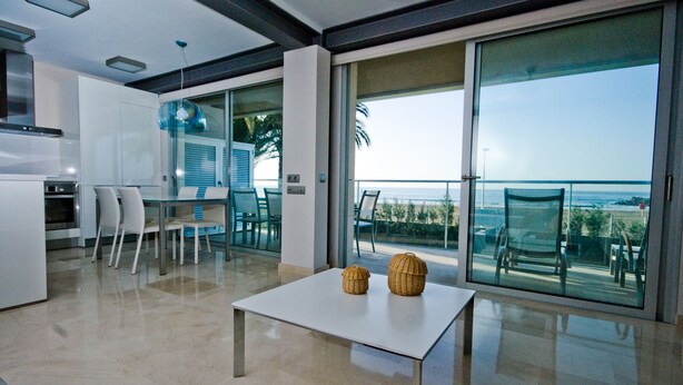 Cozinha moderna com área de jantar e varanda com vista para o oceano.