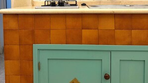 Een keuken met een betegelde achterwand, een gootsteen en een kast.