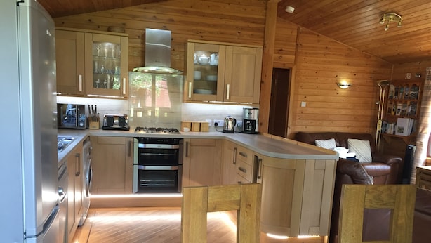 Una cocina moderna con armarios de madera, electrodomésticos de acero inoxidable y una isla central.