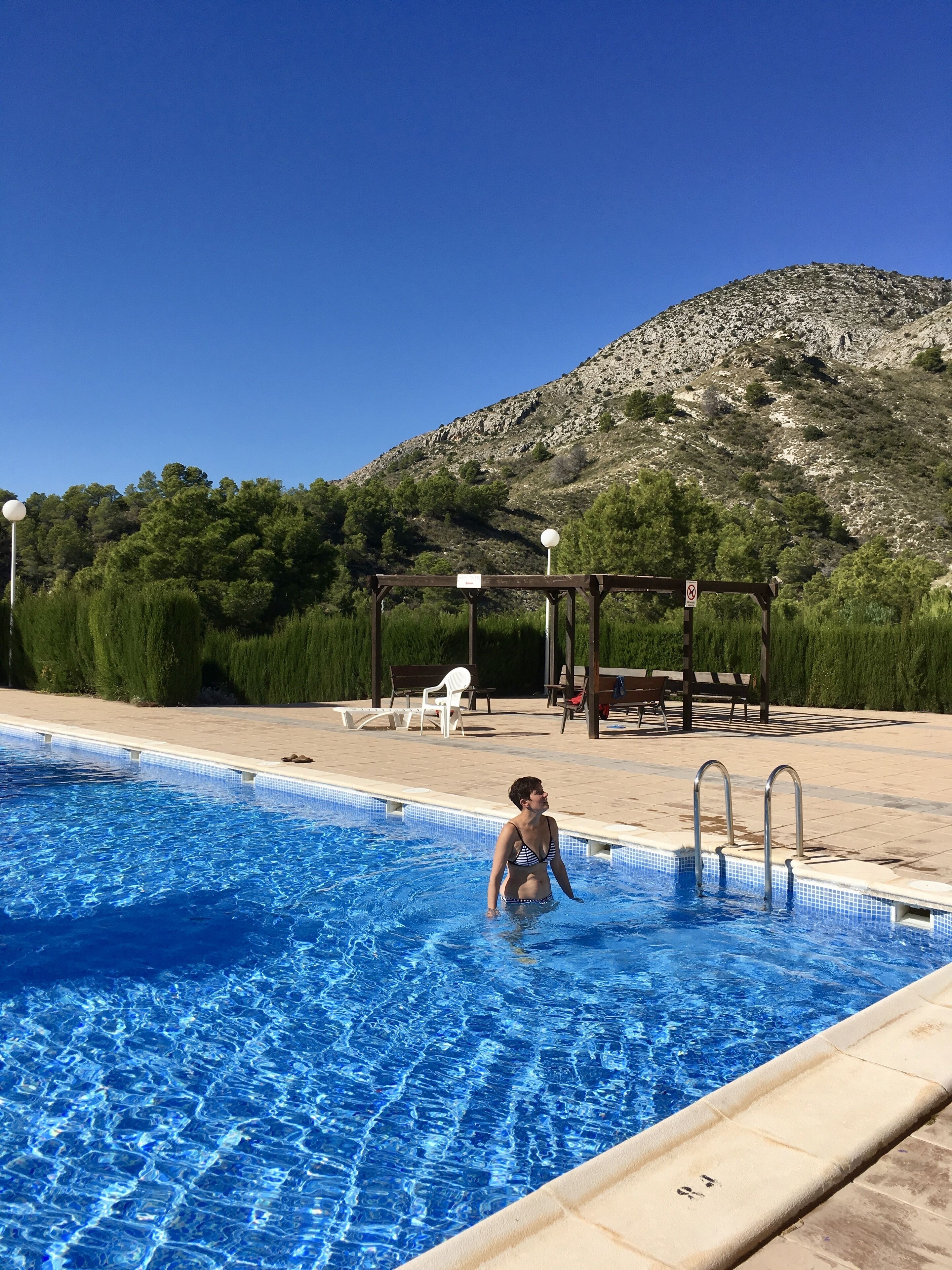 Une piscine à l’eau d’un bleu cristallin, une terrasse en bois et une vue imprenable sur les montagnes.