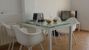 A dining area with a glass-top table, white chairs, a laptop, wine glasses, and bowls. - Near sea and quiet, beautiful view   (Altea)
