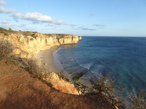 A coastal landscape with cliffs and a beach. - Well-equipped apartment with sun-drenched balcony (Lagos)