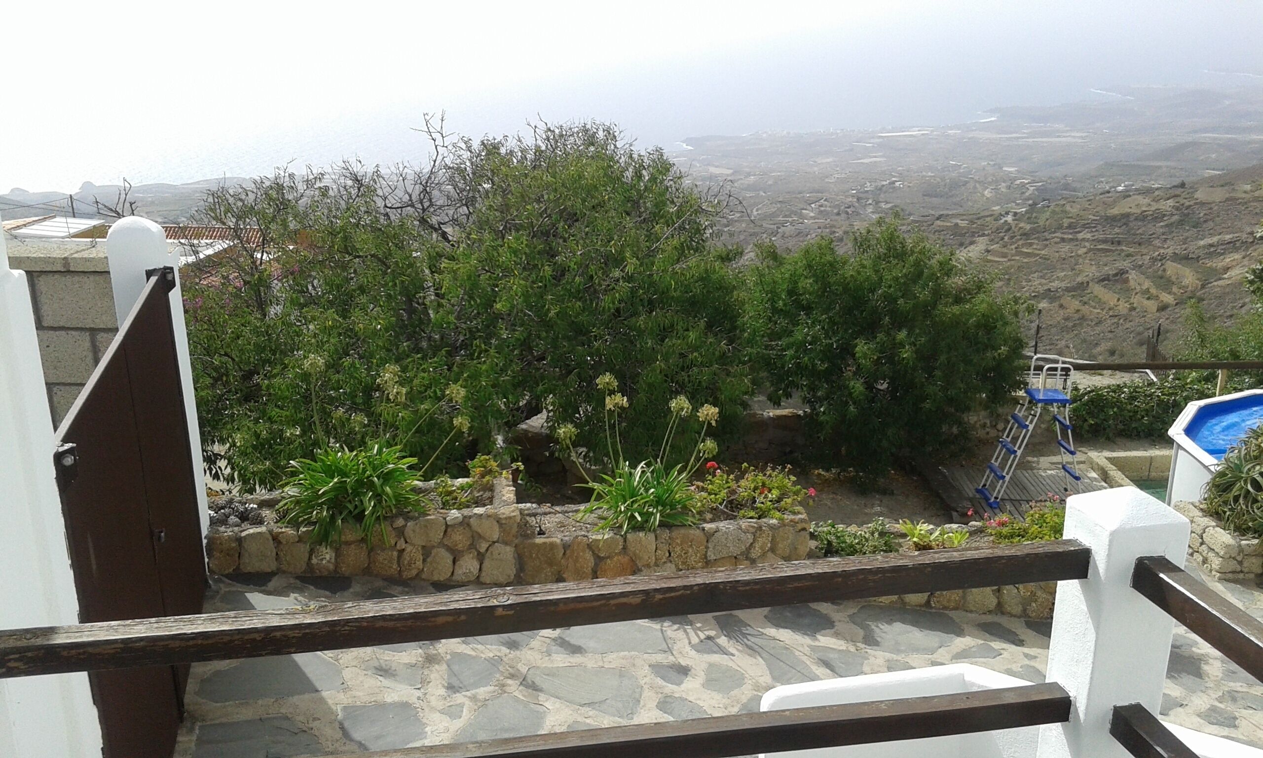 A stone staircase leading to a pool area with a view of a valley.