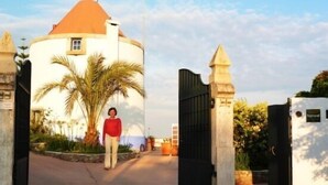 Une personne se tient à l’entrée d’un bâtiment doté d’un dôme et d’un toit rouge.