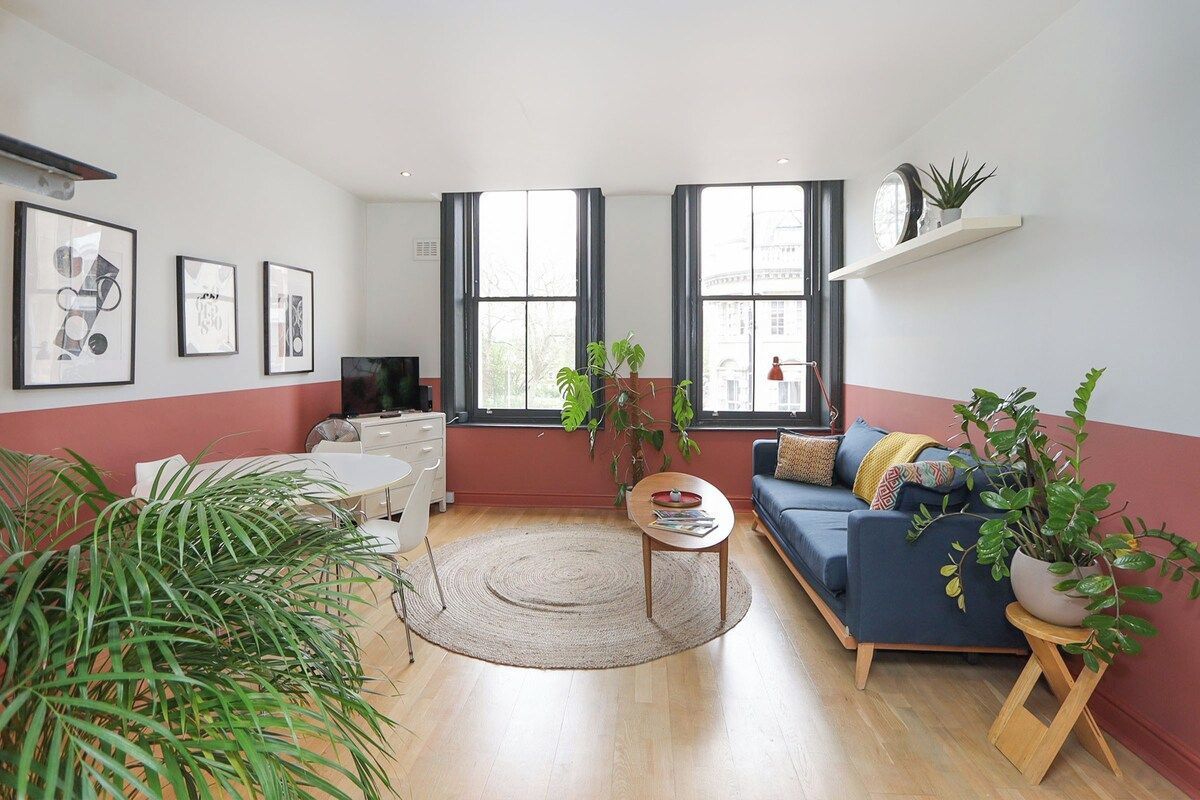 Un salon moderne avec un canapé, une table basse et une grande fenêtre.