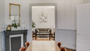 A room with a fireplace, a dining table, and a sofa.