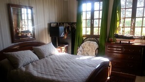 A bedroom with a large bed, a wooden dresser, a chair, and a mirror. - BLUE ROOM FOR RENT TWO STEPS FROM THE SEA (Ault)