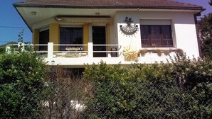 A two-story building with a balcony, a sun dial, and a small window with a decorative frame. - BLUE ROOM FOR RENT TWO STEPS FROM THE SEA (Ault)
