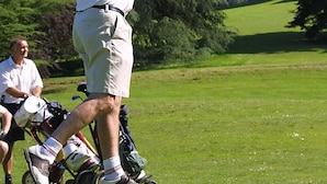 Un terrain de golf avec un grand bâtiment en arrière-plan.
