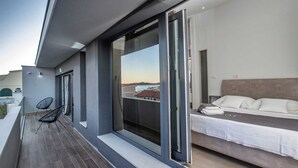 Ein moderner Balkon mit Bett, Stuhl und Blick auf die Stadt.
